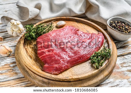 Raw Flat Iron steak on a cutting board. Fresh Marble beef meat black Angus. White wooden background. Top view ストックフォト © 