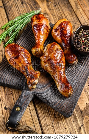 Barbecue roasted chicken drumsticks on a wooden cutting board. wooden background. top view Stock fotó © 