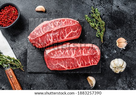 Raw organic meat Twagyu oyster top blade steak. Black background. Top view Foto stock © 