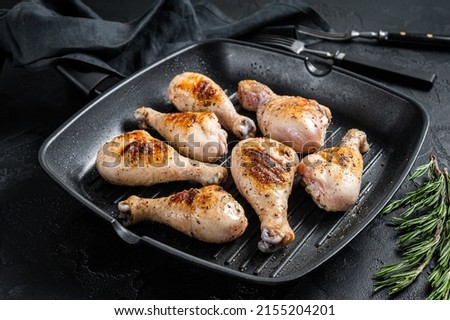 Grilled Chicken leg drumstick with herbs, poultry meat. Black background. Top view. Stock fotó © 