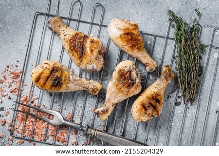 Grilled Jerk Chicken on a grill, leg drumstick poultry meat. Gray background. Top view. Stock fotó © 