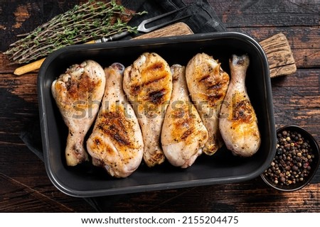 Baked Chicken legs drumstick in a baking dish with herbs. Wooden background. Top view. Stock fotó © 