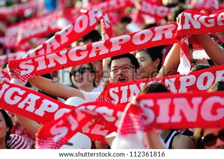 SINGAPORE - AUGUST 09: Spectators waving their Singapore scarves during National Day Parade 2012 on August 09, 2012 in Singapore