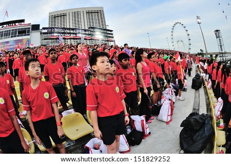 SINGAPORE - JULY 20: Spectators singing the Singapore national anthem during National Day Parade (NDP) Rehearsal 2013 on July 20, 2013 in Singapore
