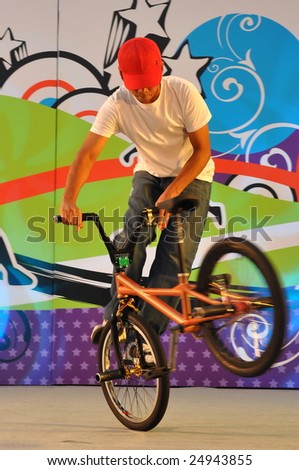 SINGAPORE - JANUARY 10: Teen performing stunts on bicycle during Singapore 2010 Youth Olympic Games logo launch ceremony January 10, 2009 in Singapore