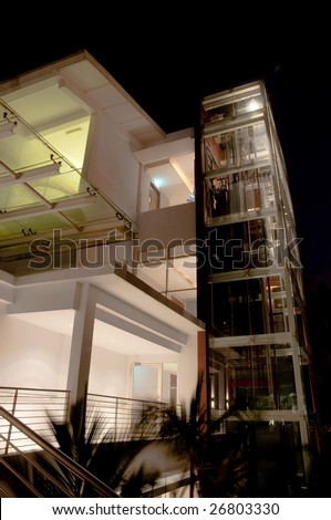 Modern building with glass elevator shaft at night