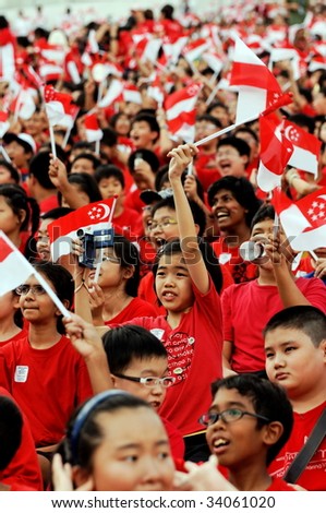 SINGAPORE - JULY 11: Primary school students waving Singapore flags during National Day Parade Combine Rehearsal July 11, 2009 in Singapore