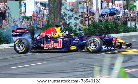 SINGAPORE - APRIL 24: David Coulthard performing donuts in the Red Bull Racing F1 car RB6 during Red Bull Speed Street Singapore on April 24, 2011 in Singapore.