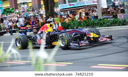 SINGAPORE - APRIL 24: David Coulthard drives the Red Bull Racing F1 car RB6 to perform stunts during Red Bull Speed Street Singapore on April 24, 2011 in Singapore.