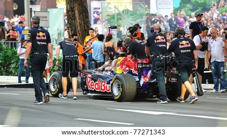 SINGAPORE - APRIL 24: Mechanics pushing the Red Bull Racing F1 car RB6 back to pit after a demonstration by David Coulthard during Red Bull Speed Street Singapore on April 24, 2011 in Singapore.
