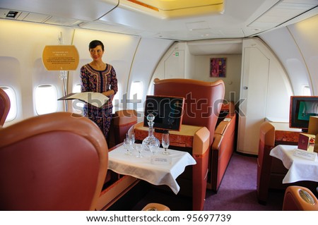 SINGAPORE - FEBRUARY 12: First class cabin with Singapore girl in Singapore Airlines\' (SIA) last Boeing 747-400 aircraft at Singapore Airshow February 12, 2012 in Singapore
