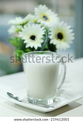 Hot milk in a glass with Flowers