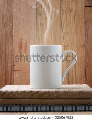 White Coffee cup on wooden table.Starting work.