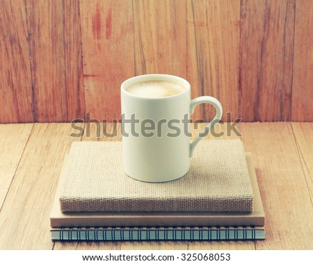 White Coffee cup on wooden table.Starting work-vintage effect.