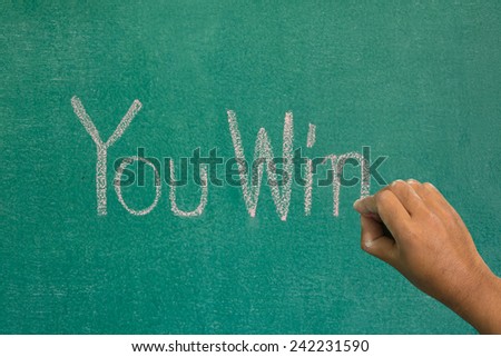Hand pointing at you win  word of success concept on chalkboard
