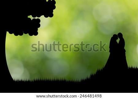 Silhouette couple stand on the grass green background