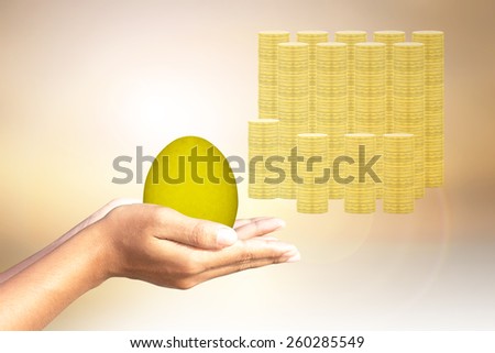 Golden egg golden coins background in human hands.