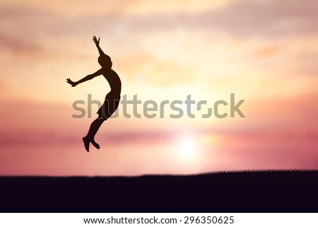 Silhouettes of children jumping on the grass. Sunset background