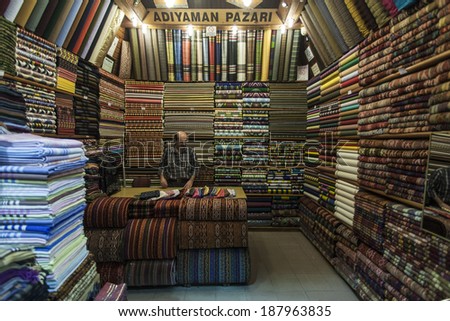 ISTANBUL, TURKEY - MAY 17, 2011: A seller stands behind the counter of a retail store, with textile, arranging his merchandise, in order to sell it to his future customers.