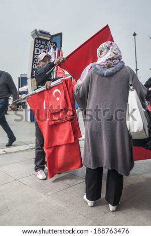 ISTANBUL, TURKEY - MAY 20, 2011: An old man sells a turkish flag to a Muslim woman, during the national elections period in Turkey, in order to make a living.