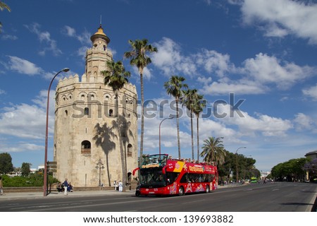 SEVILLE, SPAIN - MAY 16: A City Sightseeing tour bus at the Torre de Oro on May 16, 2013 in Seville, Spain. City Sightseeing operates in 100 cities worldwide and carries 8 million passengers per year.