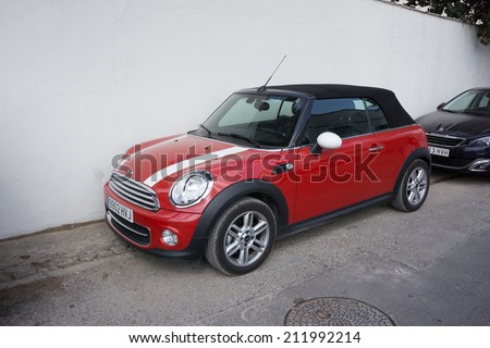 VALENCIA, SPAIN - AUGUST 20, 2014: Mini Cooper car parked in the street in Valencia, Spain.  In 1999 the Mini was voted the second most influential car of the 20th century, behind the Ford Model T.