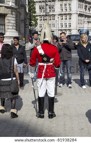 LONDON - MAY 31: Tourist snap photos in front of the Horse Guard Building on May 31, 2011 in London. Troopers of the Queens Cavalry have been posted in front of the Horse Guard Building for 130 years.