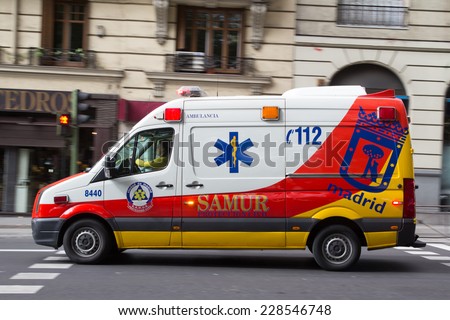MADRID, SPAIN - OCTOBER 9, 2014: An ambulance speeding through the streets of Madrid. Due to Spanish law, only police use blue lights and ambulances and fire engines have to use amber lights.