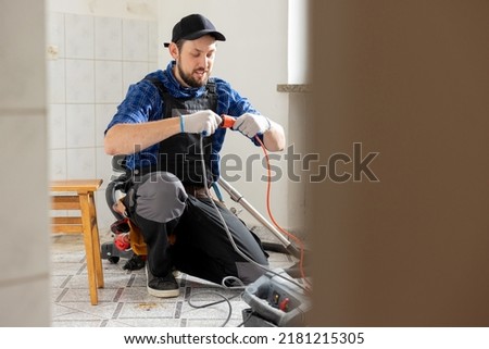 Connecting cables with a plug, extension cord plugging in construction equipment, breakdown, short circuit in house during renovation experienced man in field of electricity repairs electrical. Stockfoto © 