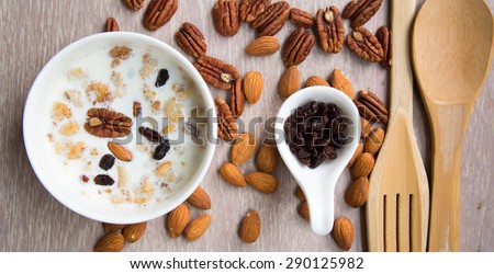 Healthy breakfast set with almonds raisins walnuts cereal and milk