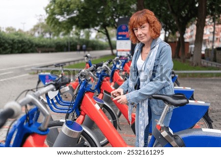 Similar – Image, Stock Photo Middle aged woman riding his electric scooter and looking at mobile phone.