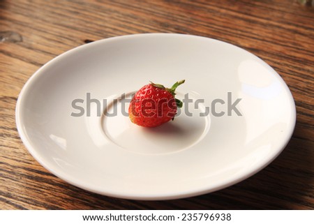 Succulent juicy fresh ripe red strawberries on an old wooden textured table top