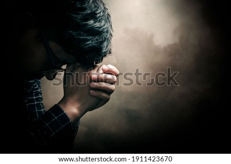 Christian life crisis prayer to god. Man Pray for god blessing to wishing have a better life. man hands praying to god with the bible. believe in goodness. Holding hands in prayer, eyes closed.