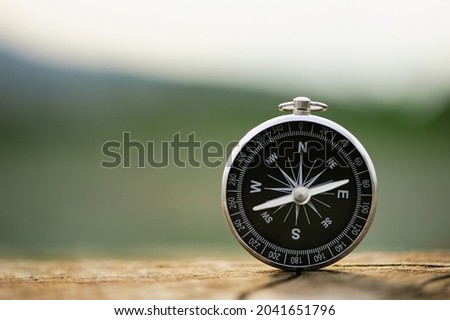 Classic compass on a wooden vintage with a green background. compass for a symbol of tourism with compass, travel with a compass, life direction concept.