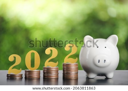 2022 New year saving money and financial planning concept.  gold wooden number 2022 on a stack of coins for investment, and banking.