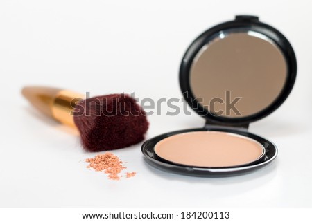 Cosmetics - powder makeup foundation and brush along with broken up foundation, with shallow depth of field