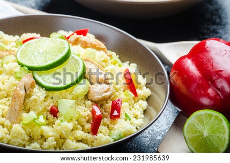 Couscous with grilled chicken meat and vegetables, fresh lime on top