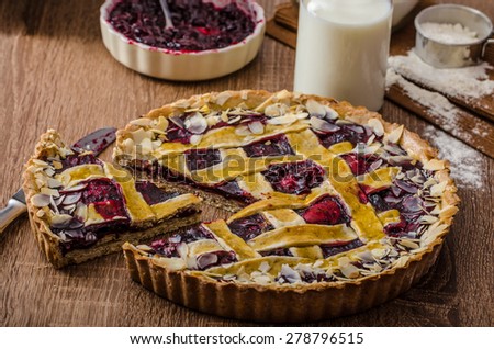 Shortbread tart with cherries, with beautiful grid, sprinkled with almonds