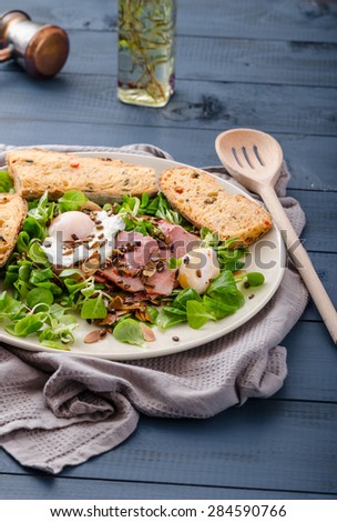 Lamb\'s lettuce salad with roasted nuts, smoked rump and poached egg, rustic italian bread with olives