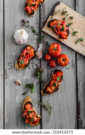 Bruschetta with tomatoes, garlic and herbs, czech delicious garlic home grown on bio garden, roasted in oven