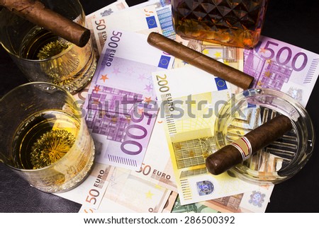 Decanter of whiskey and a glass with cuban cigar,euro money