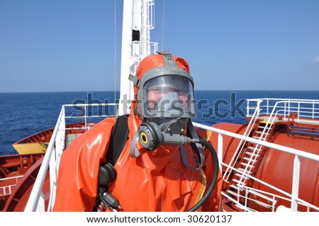 man in chemical suit on deck of chemical tanker