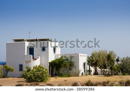 Small white and blue house over blue sky