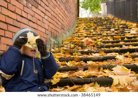 Small boy goofing around in autumn scenery