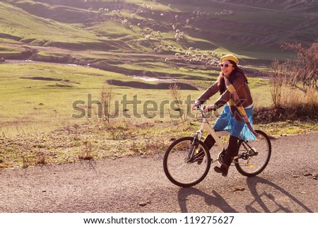 Beautiful woman riding a bicycle in the countryside