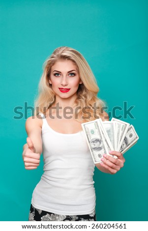 A young woman with dollars in her hands and showin g ok, isolated on white background