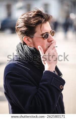 Young handsome businessman posing, Portrait of fashion man on street, blurred city background