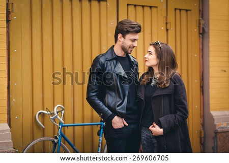 Outdoor lifestyle portrait of young couple in love standing in old town on the street, bike, hipsters,