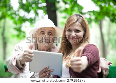 Grandmother and granddaughter approve the technology. tablet. show thumb