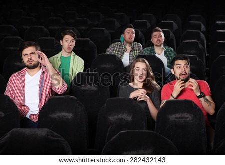 merry company in the cinema,\
young people watch movies, film,